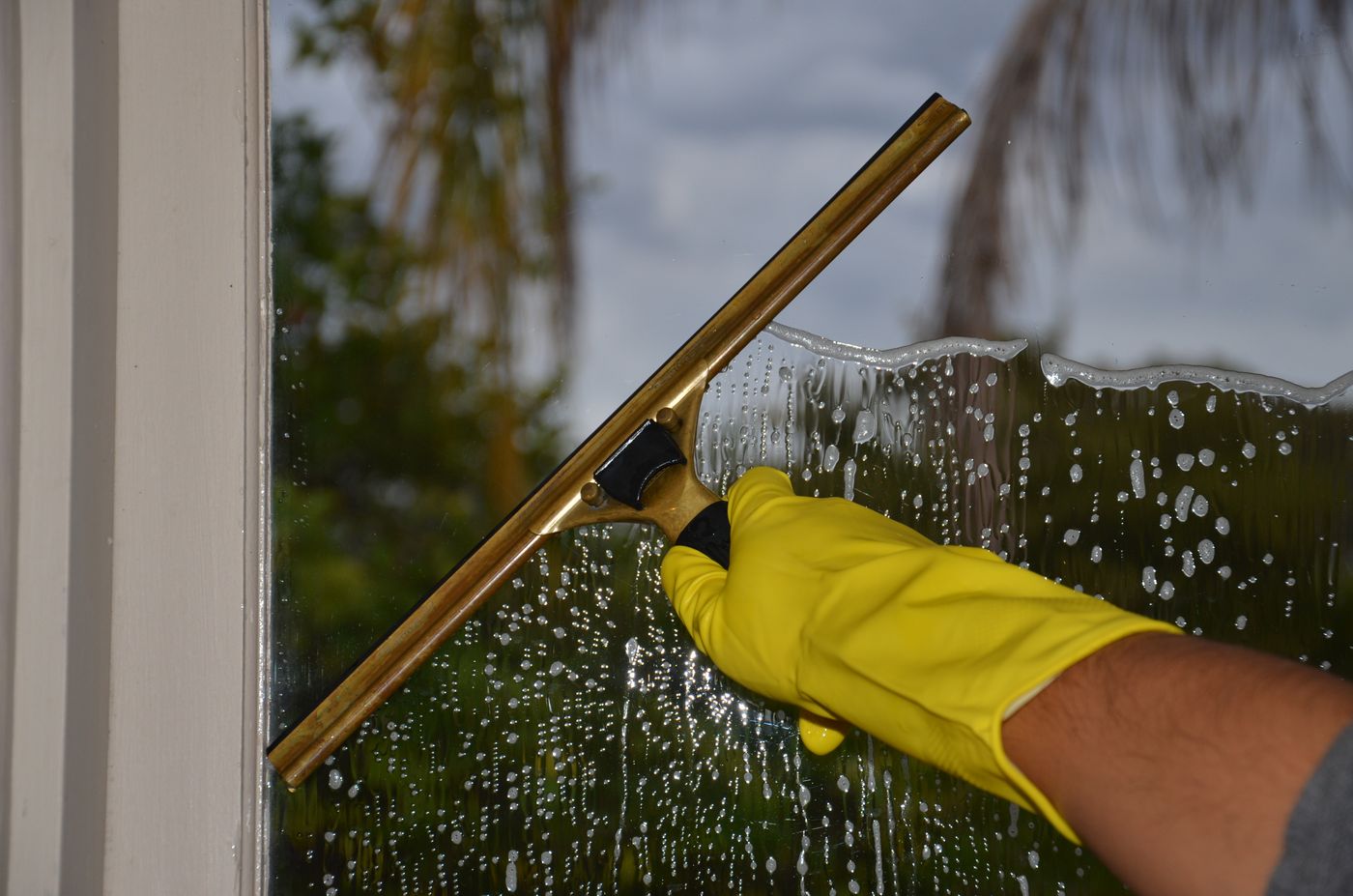 Professional squeegee cleaning a residential window